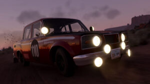 A modified rally car speeds down a dirt road, illuminated by multiple headlights against a dusky sky.