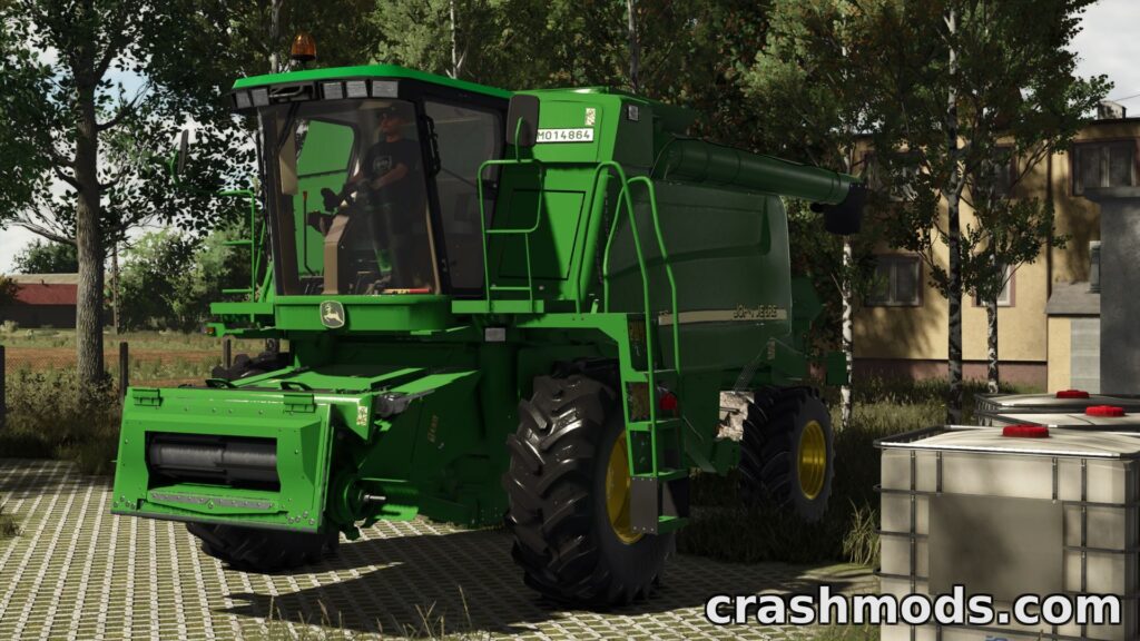John Deere WTS Series harvester parked in a detailed farm setting, ready for harvesting tasks in Farming Simulator 25.