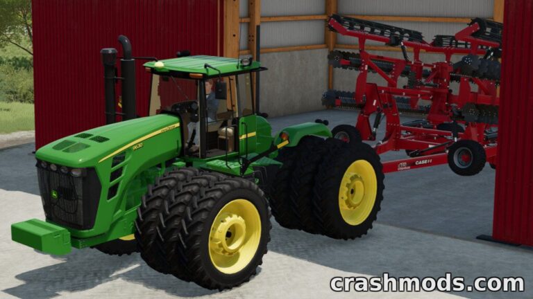 The John Deere 9020 tractor is parked inside a shed, ready to attach a red cultivator for Farming Simulator 22.