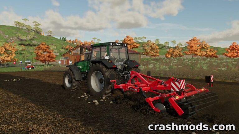 A green tractor pulls the Kuhn Cultimer L300 cultivator, tilling soil in a scenic autumn landscape.