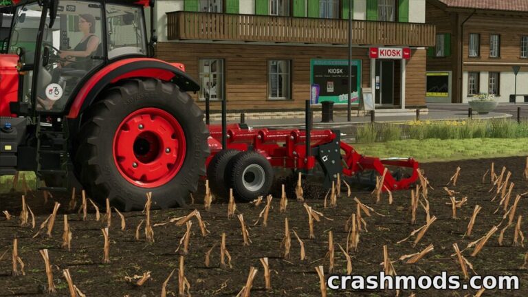 A red tractor equipped with a Metal-Fach U484 subsoiler is working the field, preparing the soil for planting.