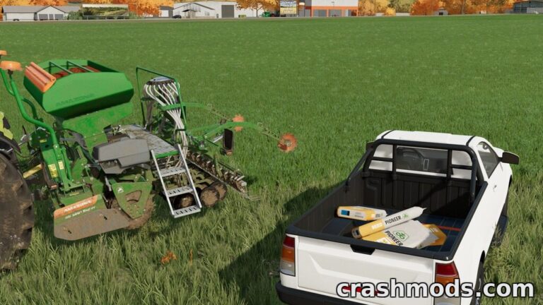 A pickup truck loaded with seed bags is parked next to a seeder in a lush green field in Farming Simulator 22.