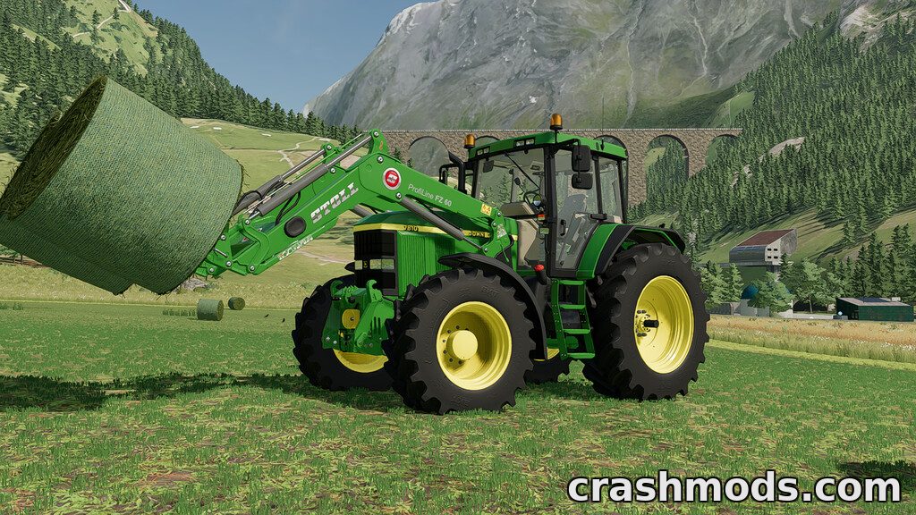 A John Deere tractor equipped with a front loader lifts a round hay bale in a picturesque farming landscape.