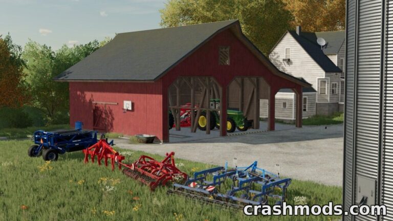 Red barn with a repair shop houses tractors and farming equipment, surrounded by lush greenery in Farming Simulator 22.