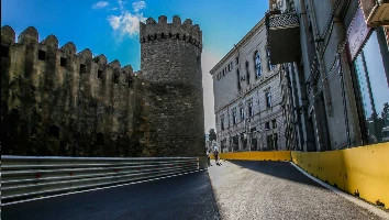 A sharp turn on the Baku GP 2022 circuit, showcasing the historic castle wall and modern street layout.